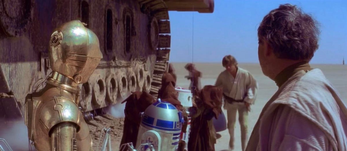 R2-D2 and C-3PO from A New Hope (1977) — standing in the Jawa sandcrawler lineup with other caged droids.